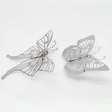 Het Vlinders Metalen Bouwpakket (Set van 2) van SlimSpul nederland b.v. bevat delicate, zilveren insectenmodellen met uitgesneden patronen, perfect als elegante vlinders decoratie voor elk kapsel.