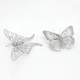 Het Vlinders Metalen Bouwpakket (Set van 2) van SlimSpul nederland b.v. heeft delicate metalen vlindermodellen in metalen modelbouwstijl, met transparante vleugels - één open, één gedeeltelijk gesloten - op een witte achtergrond.