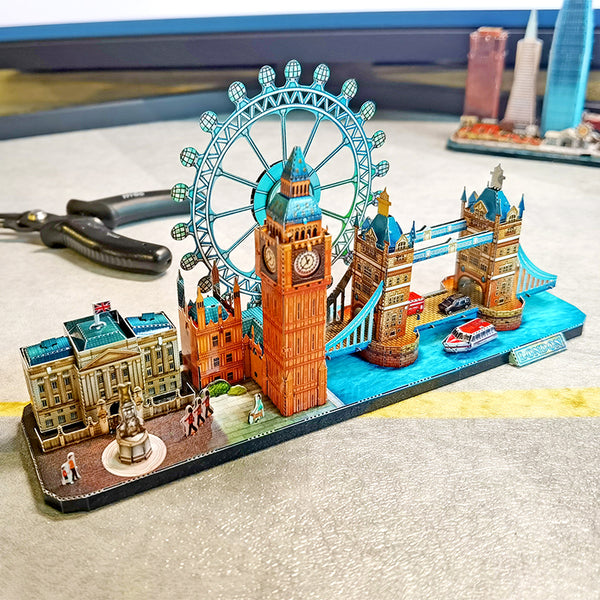 Het Stadsgezichten Metalen Bouwpakket (Diverse Steden) van SlimSpul nederland b.v. is een architectuur miniatuur met beroemde Londense bezienswaardigheden, figuren en een rode laars als tafeldecoratie.