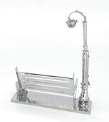 Het Parkbankje met Lantaarn Metalen Bouwpakket - Miniatuur Stadsgezicht van SlimSpul nederland b.v. is een klein metalen bouwpakket met een moderne parkbank en straatlantaarn op een voet van stoeptegels voor een stijlvol stadsgezicht.