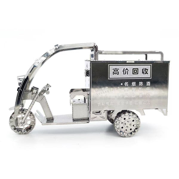 De TukTuk Metalen Bouwpakket - Aziatisch Taxi Model van SlimSpul nederland b.v. is een zilveren driewielige taxi met Chinese karakters, gedetailleerde wielen en een overdekte laadruimte, prachtig weergegeven tegen een witte achtergrond.