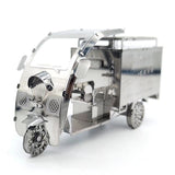 De TukTuk Metalen Bouwpakket - Aziatisch Taxi Model van SlimSpul nederland b.v. is een gedetailleerde miniatuur van een driewielige metalen autoriksja met ingewikkelde onderdelen, open cockpit en glanzend zilveren afwerking.