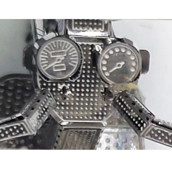 Close-up van het TukTuk Metalen Bouwpakket - Aziatisch Taxi Model van SlimSpul nederland b.v., met twee ronde wijzerplaten met verhoogde markeringen, gestructureerde oppervlakken en geometrische patronen - ideaal voor liefhebbers van metalen modelbouw.
