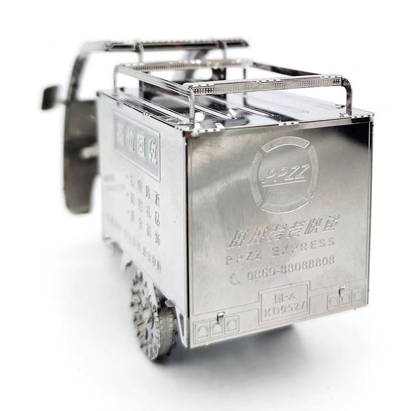 Het TukTuk Metalen Bouwpakket - Aziatisch Taxi Model van SlimSpul nederland b.v. is een klein, zilverkleurig metalen model met tekst, Chinese karakters en een logo op de achterkant en zijkanten, afgebeeld op een witte achtergrond.