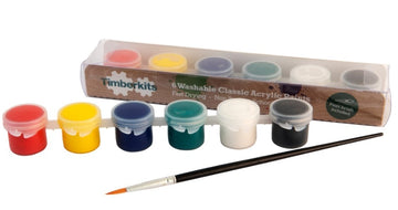 Zes kleine potjes acrylverf in geel, rood, blauw, groen, wit en zwart plus een dunne verfkwast staan voor de doos - ideaal als de SlimSpul nederland b.v. Verfset voor Houtconstructie Kits (Timberkits) - Klassiek of Speciaal.