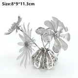 Drie gedetailleerde zilvermetalen bloemen met bladeren komen uit een decoratieve basis - ideaal als het Vaasje met Bloemen Metalen Bouwpakket - Sierlijke Decoratie van SlimSpul nederland b.v. Afmetingen: 8*9*11,3 cm weergegeven in zwarte tekst bovenaan.