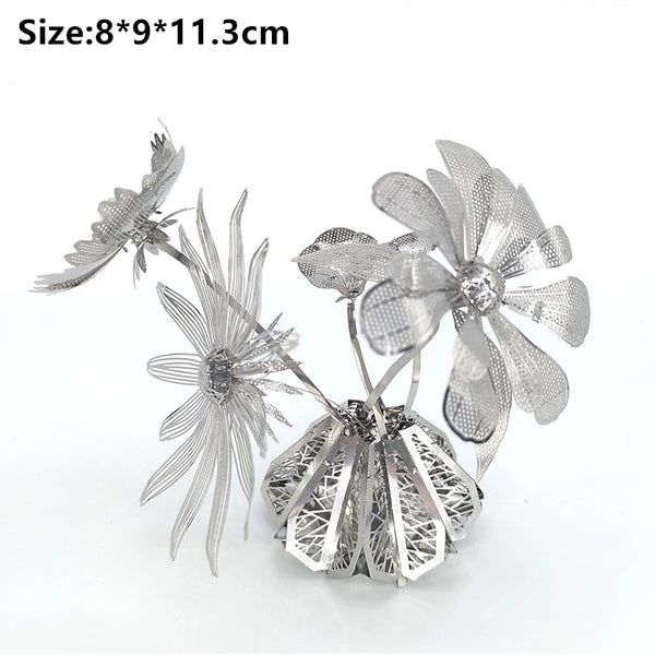 Drie gedetailleerde zilvermetalen bloemen met bladeren komen uit een decoratieve basis - ideaal als het Vaasje met Bloemen Metalen Bouwpakket - Sierlijke Decoratie van SlimSpul nederland b.v. Afmetingen: 8*9*11,3 cm weergegeven in zwarte tekst bovenaan.