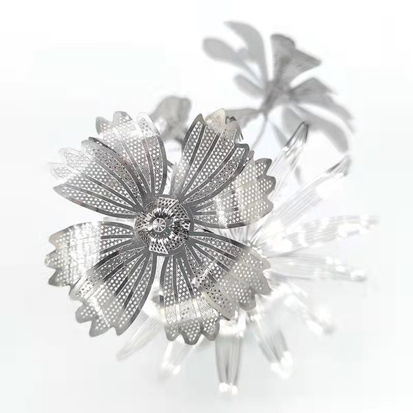 Close-up van het Vaasje met Bloemen Metalen Bouwpakket van SlimSpul nederland b.v.; metallic zilveren bloemen met geperforeerde bloemblaadjes creëren een moderne, artistieke look tegen een witte achtergrond.