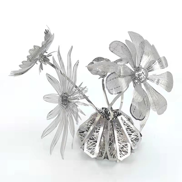 Het Vaasje met Bloemen Metalen Bouwpakket van SlimSpul nederland b.v. is een metalen modelbouw sculptuur met drie gedetailleerde bloemen en bladeren op een geometrische basis, die een elegante decoratie biedt tegen een witte achtergrond.