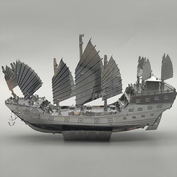 Het Schatschip van Zheng He Metalen Bouwpakket - Chinees Jonk Model van SlimSpul nederland b.v. toont een traditioneel schip met meerdere zeilen en fijne details op een lichte achtergrond, afgewerkt met een gepolijst historisch ontwerp.