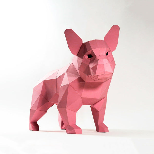Het SlimSpul nederland b.v. Franse Bulldog 3D Papier Model - Populair Hondenras Bouwpakket is een geometrische, roze papieren sculptuur met hoekige facetten, die een moderne, abstracte look biedt op elke witte achtergrond.