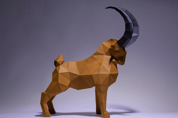 Het Steenbok 3D Papier Model - Imposant Bergdier Bouwpakket van SlimSpul nederland b.v. is een geometrische DIY sculptuur van een bruine steenbok met grote zwarte horens, perfect voor papercraft liefhebbers en interieurdecoratie.