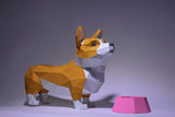 Het Corgi met Voerbakje 3D Papier Model van SlimSpul nederland b.v. toont een polygonale Corgi naast een roze hondenvoerbak op een grijze achtergrond - ideaal bouwpakket voor papercraftliefhebbers.