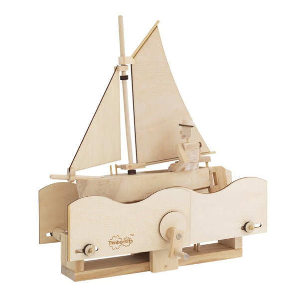 Het Zilte Zeiler Houtconstructie Bouwpakket - Schommelend Schip Model van SlimSpul nederland b.v. is een DIY Timberkits houten zeilboot met matroos, met een handzwengel die de golven en de boot op de golvende basis animeert.