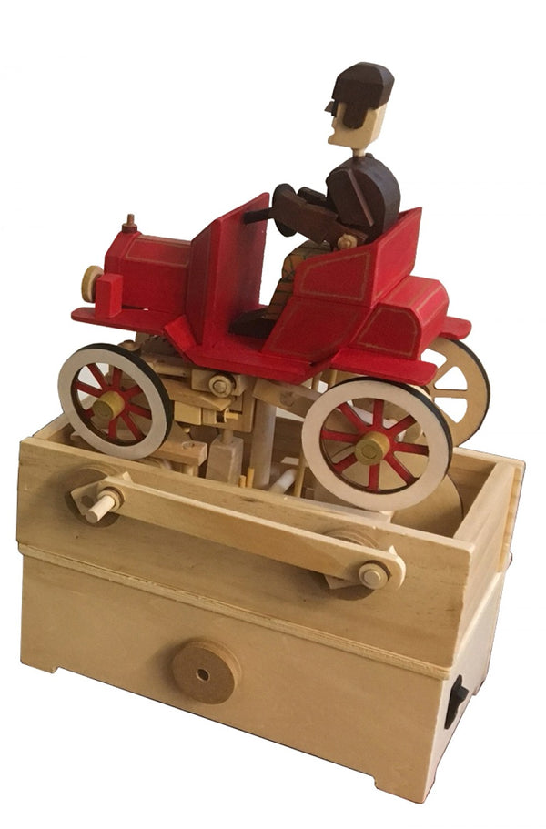 De Klassieke Auto Houtconstructie - Bewegend Oldtimer Model (Timberkits Expert) van SlimSpul nederland b.v. is een mechanisch modelbouwpakket met een houten oldtimer op een beige kist, ideaal voor liefhebbers van klassieke ontwerpen.