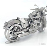 Een close-up van het Harley Davidson Motorfiets Metalen Bouwpakket - Klassiek Model van SlimSpul nederland b.v. benadrukt de ingewikkelde mechanische details, glanzende zilveren afwerking en de focus op het achterwiel en motorblok.