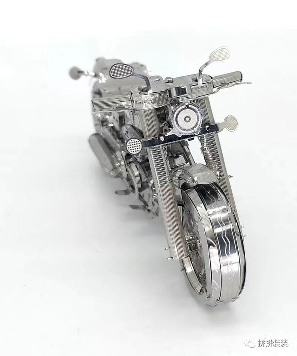 Een gedetailleerd vooraanzicht toont het Harley Davidson Motorfiets Metalen Bouwpakket - Klassiek Model van SlimSpul nederland b.v., met de nadruk op het ingewikkelde ontwerp, het grote voorwiel, het stuur en de spiegels tegen een witte achtergrond.