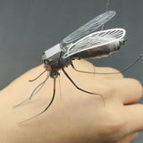 Het Tijgermug Metalen Bouwpakket - Gedetailleerd Insect Model van SlimSpul nederland b.v. toont een metalen tijgermug met fijne vleugels en poten, roestend op een hand voor een grijze achtergrond.