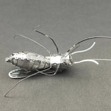 De Tijgermug Metalen Bouwpakket van SlimSpul nederland b.v. is een gedetailleerd insectenmodel met lange poten en antennes, getoond tegen een effen donkere achtergrond.