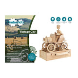 De doos van SlimSpul nederland b.v. Klassieke Auto Houtconstructie - Bewegend Oldtimer Model (Timberkits Expert) toont een houten bestuurder in een klassieke doe-het-zelf auto. Tekst vermeldt zelfbouw, leeftijden 9-90, en praktische vaardigheden; model en auto staan gemonteerd naast de doos.